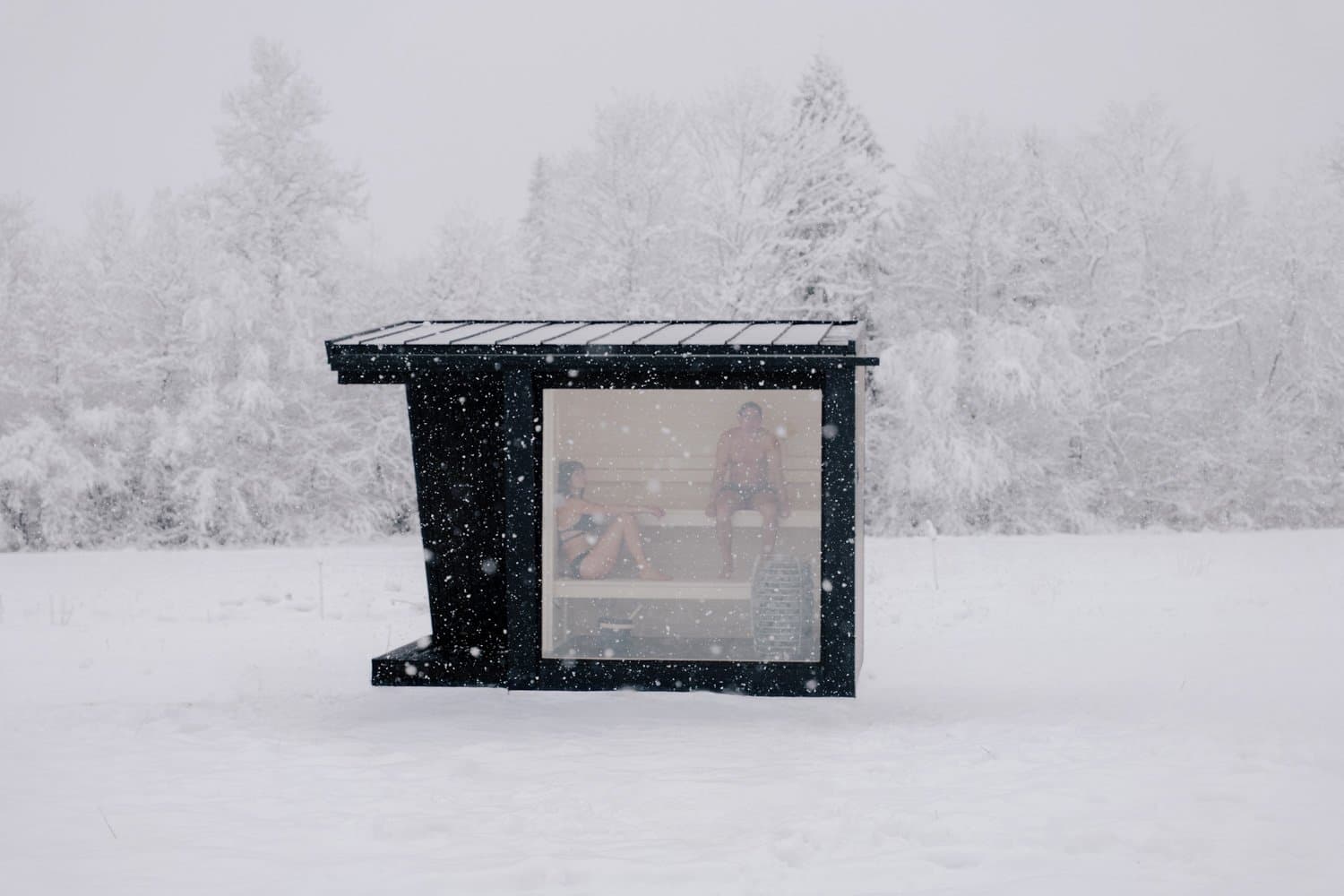 Sauna Ikigai 5 im fallenden Schnee, mit auskragender überdachter Veranda, zwei Gäste auf den Bänken