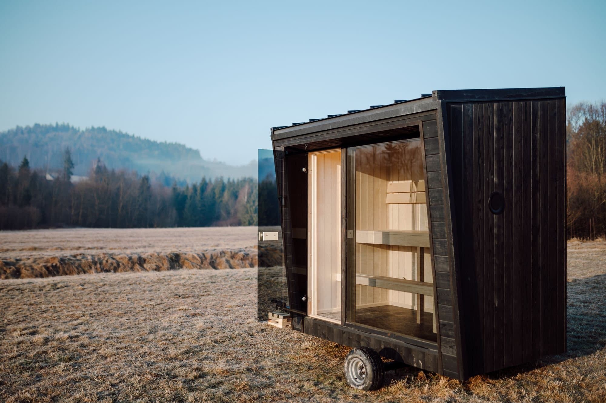 Sauna Kaizen mit geöffneter Glastür auf dem Fahrgestell, mit dem sie transportiert wird
